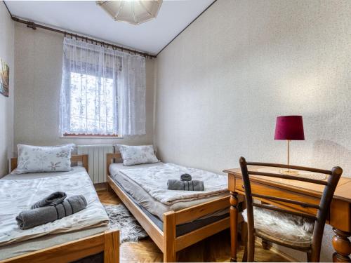 a bedroom with two beds and a desk with a lamp at Apartment Maklen-2 by Interhome in Brod Moravice