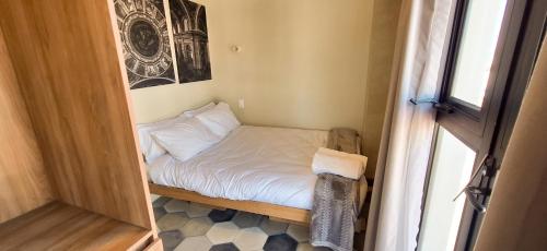 a small bed in a small room with a window at Casa 8 in Guadalajara