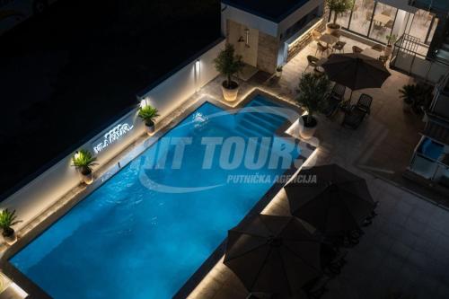 an overhead view of a swimming pool at night at Vila Kalina Apartments in Sutomore