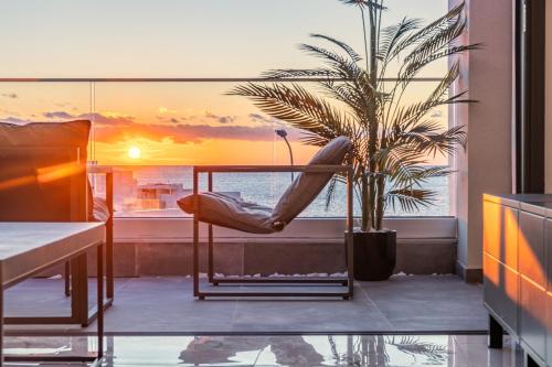 a room with a hammock on a balcony with a palm tree at HiddenGems Residences 202 - The LXR Penthouse - Pool & Beach Steps in Paphos