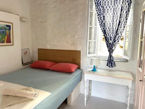 ArtemonasにあるTraditional Cycladic House with a Viewのベッドルーム1室(赤い枕のベッド1台、窓付)