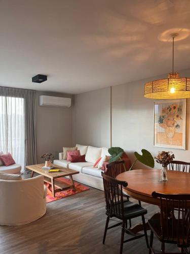 ein Wohnzimmer mit Sofa und Tisch in der Unterkunft Departamento con vista al cerro! in Yerba Buena