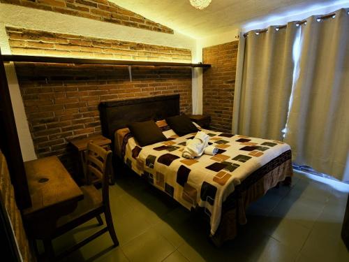 a bedroom with a bed and a brick wall at La Misión Cabañas Chignahuapan in Chignahuapan