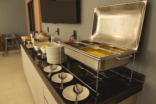 una cucina con bancone con piatti e lavandino di Hotel Caminhos da Oiticica a Jucurutu