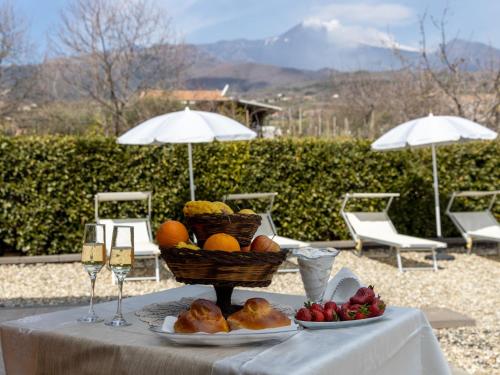a table with a basket of fruit and wine glasses at Apartment Arancio by Interhome in Zafferana Etnea