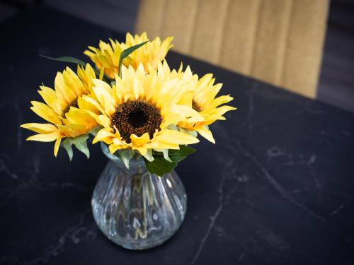 a vase filled with yellow sunflowers on a table at Apartment Harbour Nights 7F by Interhome in Lossiemouth