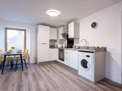 a kitchen with a washing machine and a table at Apartment Harbour Nights 7F by Interhome in Lossiemouth