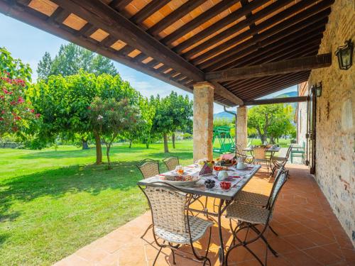 a patio with a table and chairs under a pergola at Holiday Home I Pioppi - CMA109 by Interhome in Camaiore