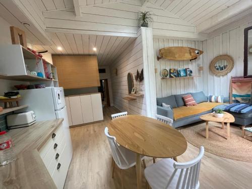 une cuisine et un salon avec une table et un canapé dans l'établissement Hossegor - Lac - Forêt - Couple - Piscine, à Soorts-Hossegor