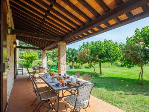 a patio with a table and chairs under a wooden pergola at Holiday Home I Pioppi - CMA109 by Interhome in Camaiore
