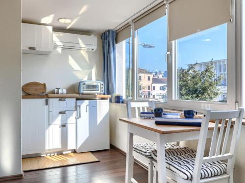 a kitchen with a table and chairs and a window at Studio Nina by Interhome in Umag