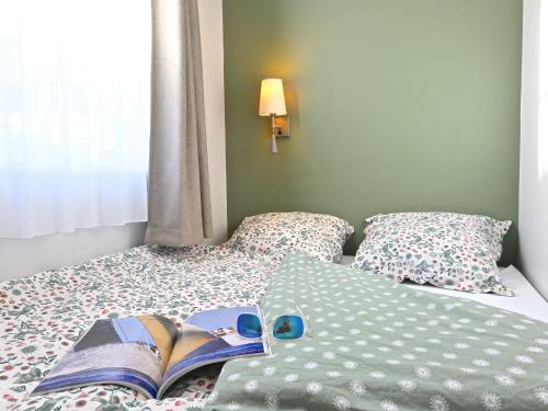 - une chambre avec un lit et un livre dans l'établissement Studio Village Cap Estérel - Le Village-83 by Interhome, à Agay