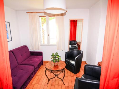 un salon avec un canapé violet et des chaises noires dans l'établissement Apartment Grenade-2 by Interhome, au Barcarès
