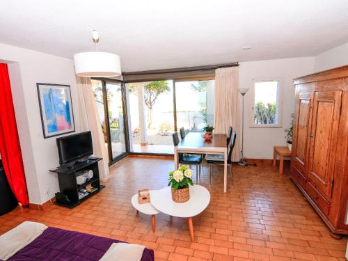 un salon avec une table et une télévision dans l'établissement Apartment Grenade-2 by Interhome, au Barcarès