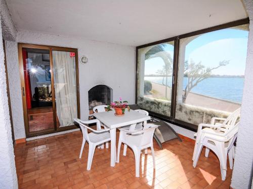 une table et des chaises dans une pièce avec vue sur l'océan dans l'établissement Apartment Grenade-2 by Interhome, au Barcarès