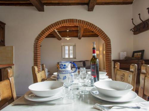 a dining room table with two bowls and a bottle of wine at Apartment Azalea by Interhome in Spianate