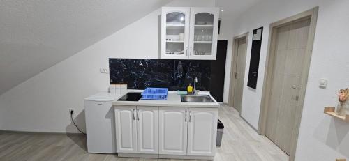 a white kitchen with a sink and a counter at Taksim Apartman 1 in Igalo