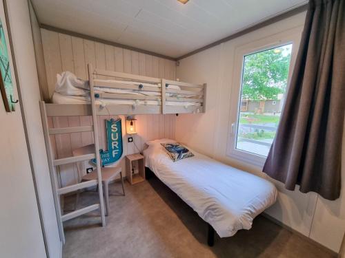- une petite chambre avec des lits superposés et une fenêtre dans l'établissement Sous la canopée - le calme au bord du lac, à Labouheyre