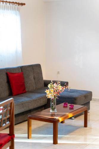 a living room with a couch and a table with flowers at Sainis Rooms in Selianitika