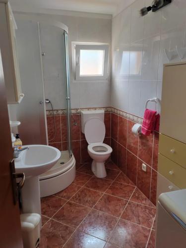 a bathroom with a toilet and a sink and a shower at Apartmani Ferri 2 in Vrbanj
