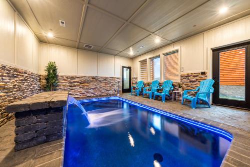 a swimming pool in a house with blue chairs at Sleeps 14 - Indoor Pool, Hot Tub, Arcade Games, Movie Theatre and Pets Welcome in Pigeon Forge