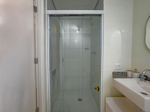 Una ducha con puerta de cristal junto al lavabo en Apollo Studio, en São Paulo