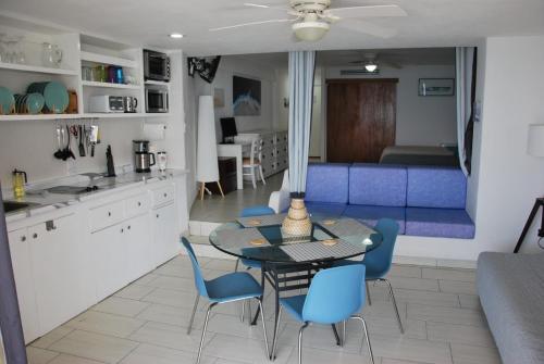 a kitchen and dining room with a table and blue chairs at Puerto Vallarta Condo Frente al mar in Puerto Vallarta