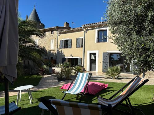- deux chaises longues assises sur l'herbe devant une maison dans l'établissement La Vade, à Carcassonne