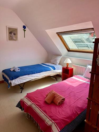 - une chambre mansardée avec 2 lits et une fenêtre dans l'établissement Port Manec'h, superbe maison au dessus de la plage, à Névez