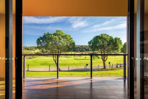 an open door with a view of a green field at NAU Morgado Golf & Country Club in Portimão