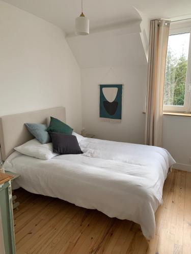 a large white bed in a room with a window at Charmante maison du vieux Coutainville, à 15mn à pied de la mer, classée 3 étoiles in Agon Coutainville