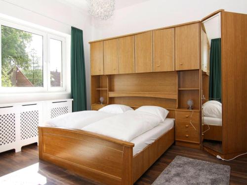 a bedroom with a large wooden bed and a window at Ferienhaus Yvonne in Wendorf im Bernstein Resort in Wendorf