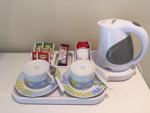 a tray with two tea cups and a coffee maker at Villa Le Favole in Sant'Egidio del Monte Albino