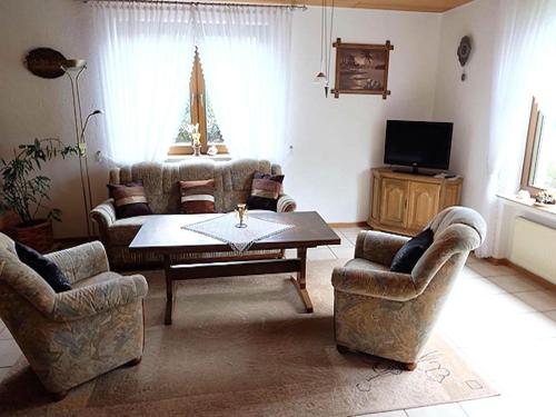 ein Wohnzimmer mit Sofas, Tisch und Fernseher in der Unterkunft Apartment in Eifel near Nürburgring in Oberstadtfeld