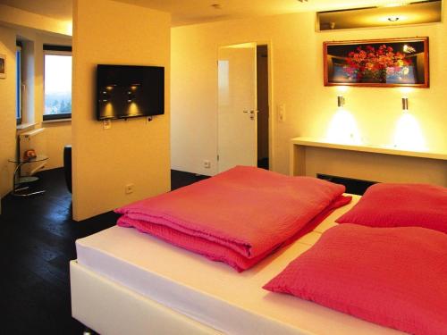 a bedroom with two red pillows on a bed at Ferienwohnung im Wasserturm, Güstrow in Güstrow