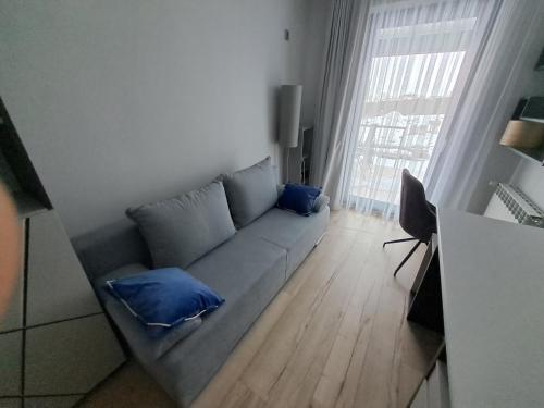 a living room with a couch with blue pillows at Cobalt Apartments in Mikołajki