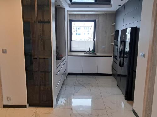 a large kitchen with a sink and a refrigerator at Cobalt Apartments in Mikołajki