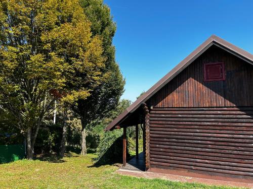 a large wooden building with trees in the background at Jazvenik Hill House in Sisak