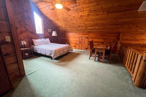 1 dormitorio en una cabaña de madera con cama y escritorio en Best Kept Secret, en Blue Ridge