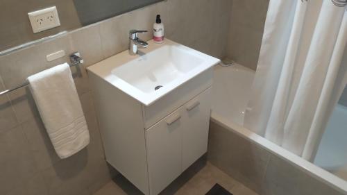 a white bathroom with a sink and a shower at Ameli in Neuquén
