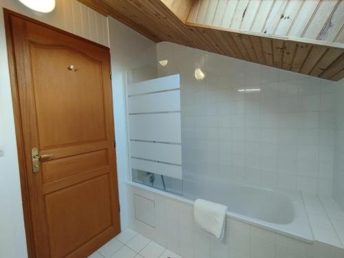 a bathroom with a shower and a wooden door at L'Auzacoise, chalet tout confort pour un séjour inoubliable in Lachapelle-Auzac