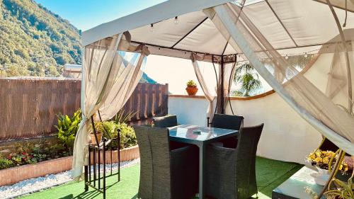 a patio with a table and chairs under a canopy at Maison Mari in Termini