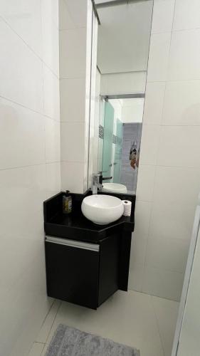 a bathroom with a sink and a mirror at Apartamento de luxo no Guaruja in Guarujá