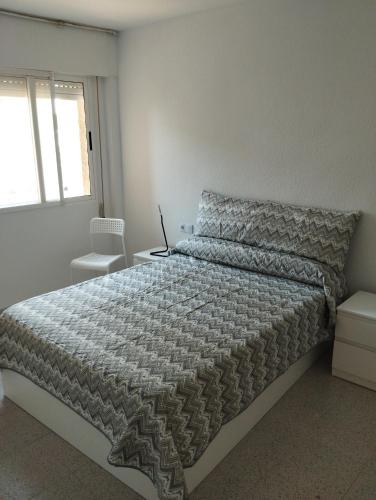 a bedroom with a bed with a laptop on it at El buen sol de la manga in La Manga del Mar Menor