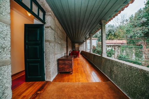 a hallway with a green door and a wooden floor at Quarto Duplo com Jardim e Piscina in Póvoa de Lanhoso