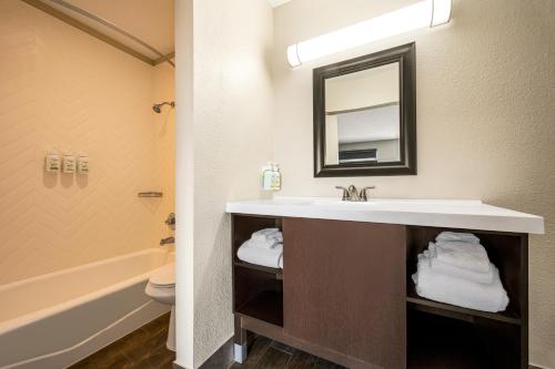 a bathroom with a sink and a tub and a toilet at Baymont by Wyndham Kingman in Kingman