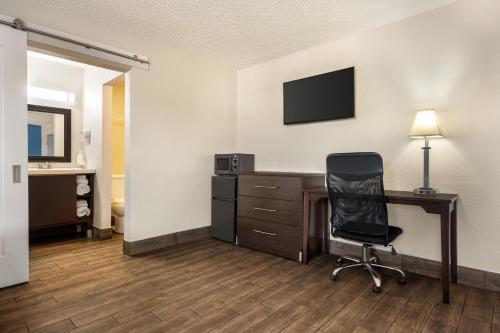 a room with a desk with a computer and a chair at Baymont by Wyndham Kingman in Kingman