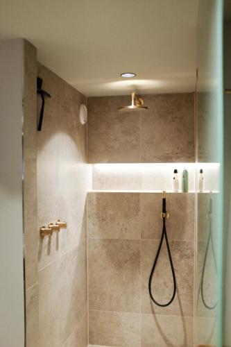 a bathroom with a shower with a glass door at Domnacht aan de gracht in Utrecht