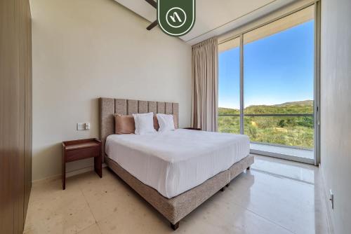 ein Schlafzimmer mit einem großen Bett und einem großen Fenster in der Unterkunft Oceanview Penthouse in Punta Mita - Beach - Pools in Higuera Blanca