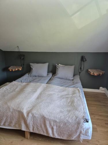 a bedroom with a large bed with two pillows at Cosy country house near city in Jönköping